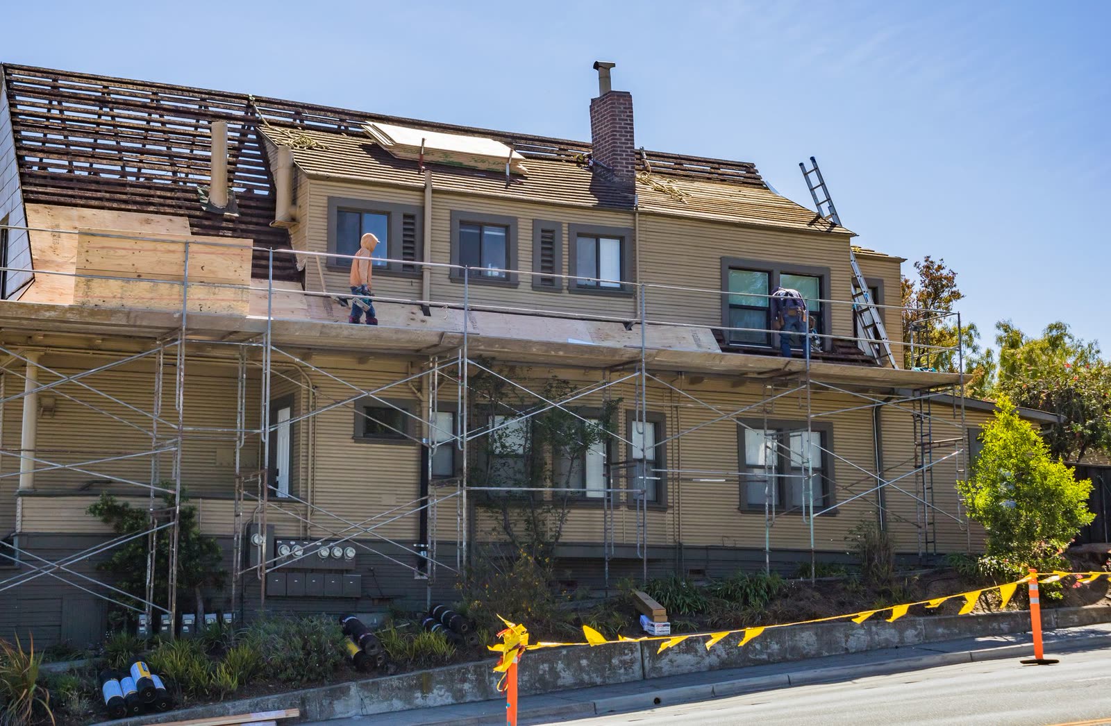 Maison sous échafaudage pendant des travaux de couverture