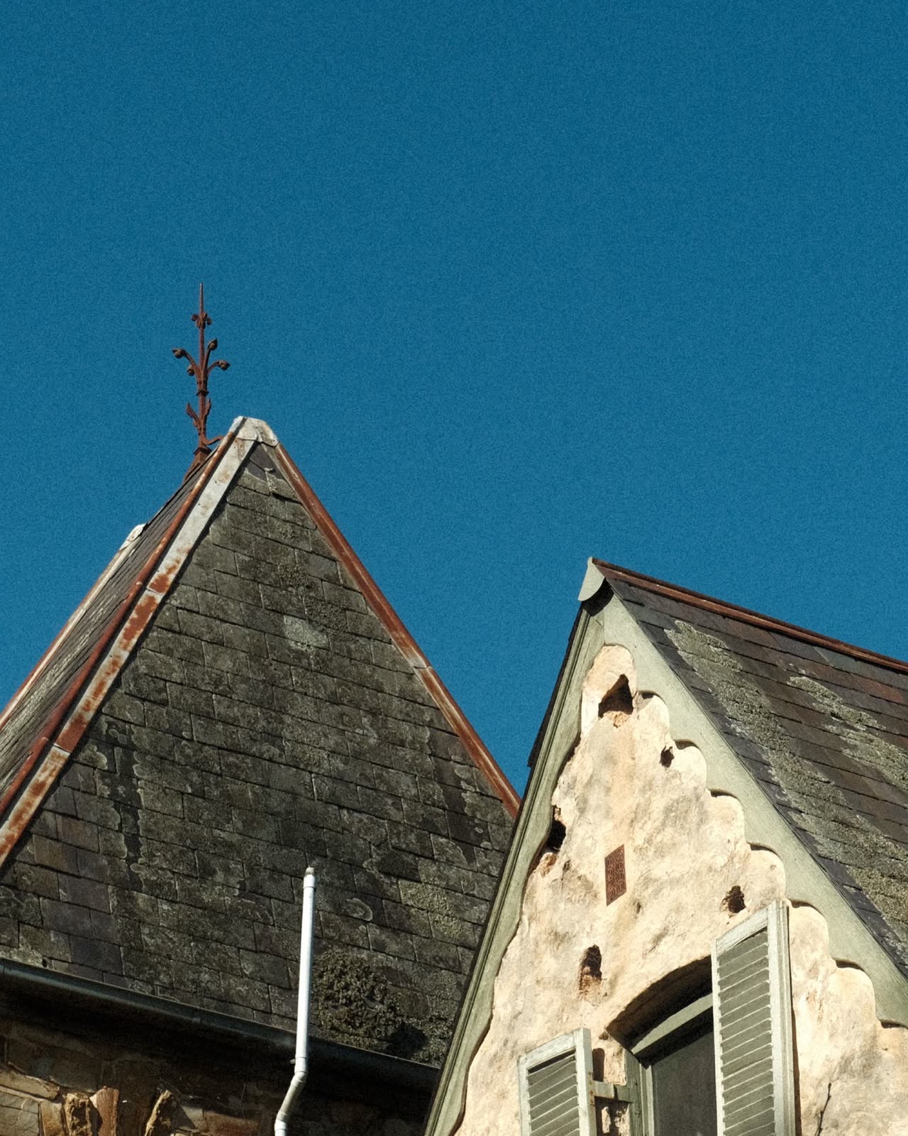 Toitures en ardoise de deux pignons sous un ciel bleu