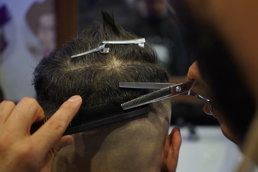 Ciseaux effileurs sur des cheveux texturés, vue de dessus