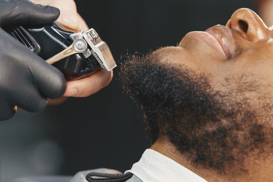 Tondeuse sur une barbe fournie, gros plan sans visage