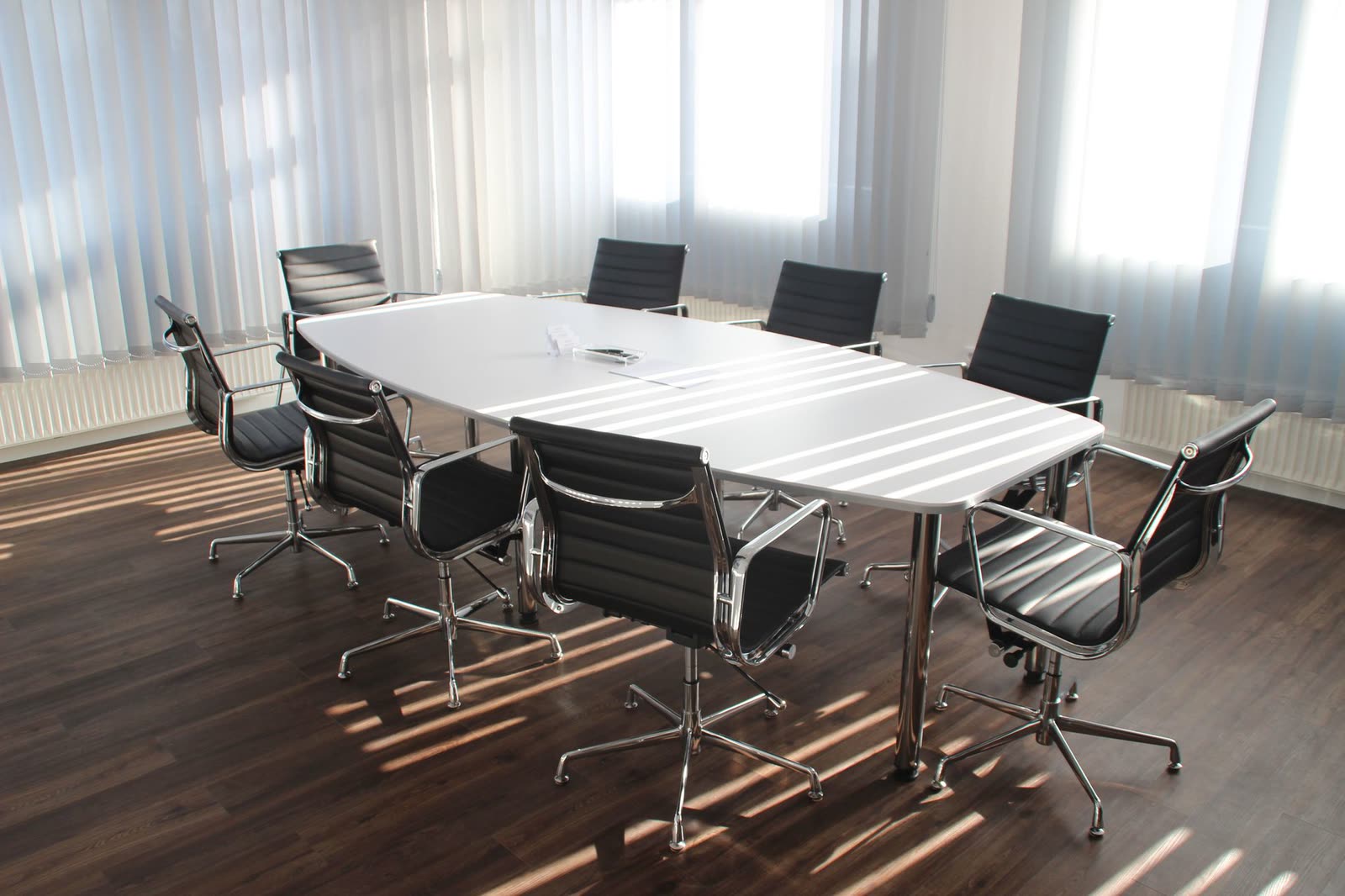 Salle de réunion du cabinet, table ovale et lumière filtrée