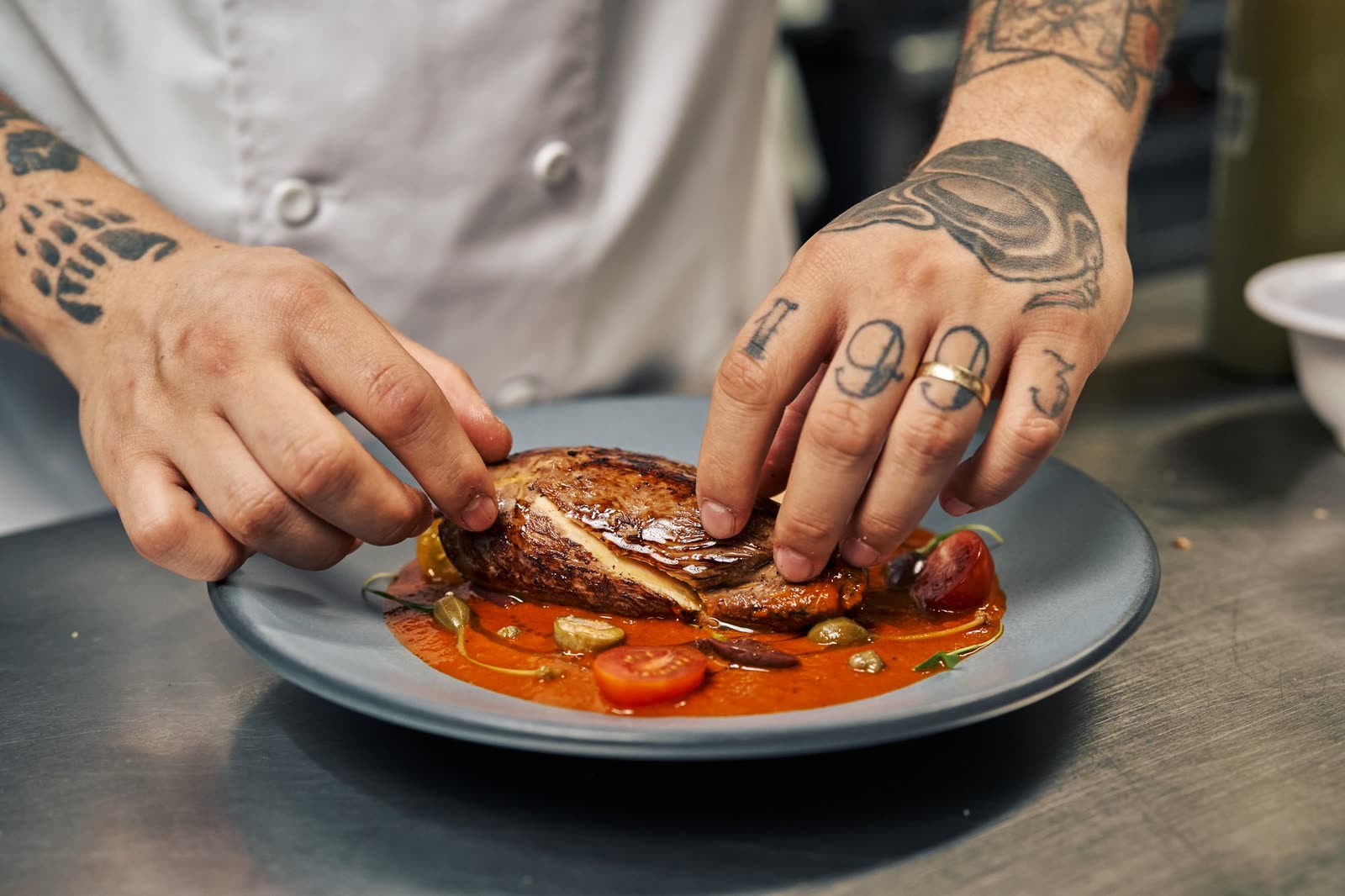 Mains d'une cuisinière dressant une assiette